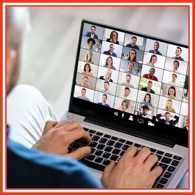 Image shows hands typing on a laptop, on the screen are lots video call participants